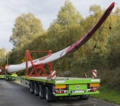 Roadside parking convoy of special trucks with oversize loads transporting rotor blades for wind power plant turbines
